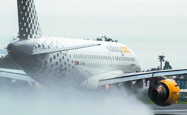 Una de las aeronaves de Vueling maniobra en la pista mojada del aeropuerto de Hondarribia.