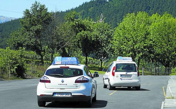 Dos coches de autoescuelas salen de la pista de examen de Olaberria este verano.