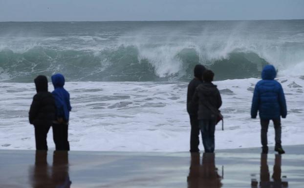 Varios niños contemplan las olas en Zarautz. /Lusa