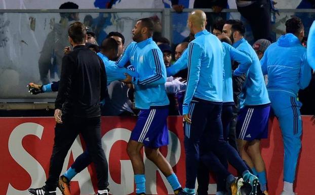 Patrice Evra, de espaldas y rodeado por sus compañeros, se enfrenta a un aficionado portugués. /Afp