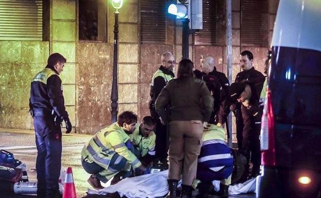 Los sanitarios practican a la víctima maniobras de reanimación en el paso de cebra de la calle Navarra donde se produjo el asalto. /Calabor