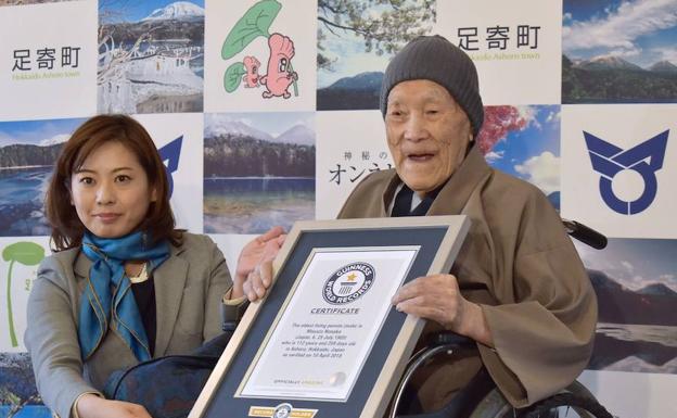 Masazo Nonaka ha sido reconocido este martes como el hombre más viejo del mundo. Erika Ogawa, vicepresidenta del Guiness de los Récords de Japón, le ha entregado una placa conmemorativa. /AFP