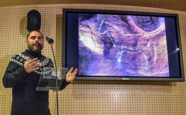 El arqueólogo Diego Garate, con uno de los grabados de la cueva de Atxurra./EFE