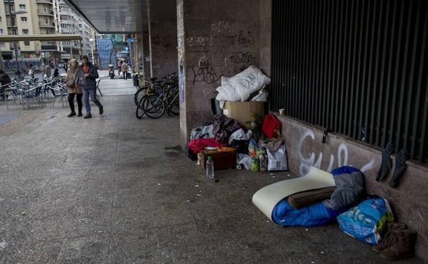 Personas sin techo con sus enseres en el barrio donostiarra de Gros. /MICHELENA