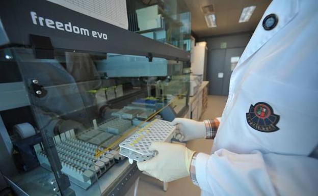 Un agente del laboratorio de la Policía Científica sostiene varias muestras de ADN en la central de la Ertzaintza en Erandio./Borja Aguado