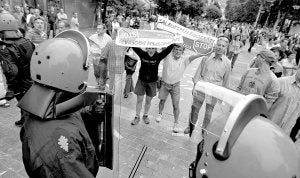 Manifestantes muestran pancartas y se encaran a los agentes de la Ertzaintza, ayer en Donostia. /LOBO ALTUNA/