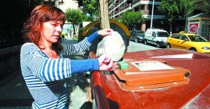 Una mujer abre con su llave el contenedor destinado a restos de comida, situado en el barrio donostiarra de Amara. ::
MIKEL FRAILE/
