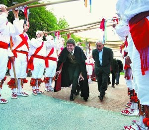 El alcalde, Ibai Iriarte, y Ramón Labaien, pasan debajo de los arcos formados por los bordones ayer por la tarde en la entrada del Prado Grande de Igarondo. :: KLISK/