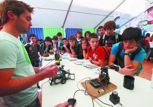 Robótica. Unos estudiantes observan con curiosidad las 'tripas' del robot en uno de los stands. :: LUSA/
