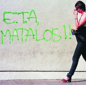 Una mujer pasa ante una pintada en una calle de Andoain hace más de una década. :: AP/