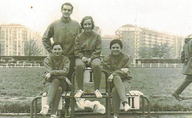 Tres mujeres de la sección de atletismo de la Real Sociedad posan en un podio junto a Pedro Ozcariz. 