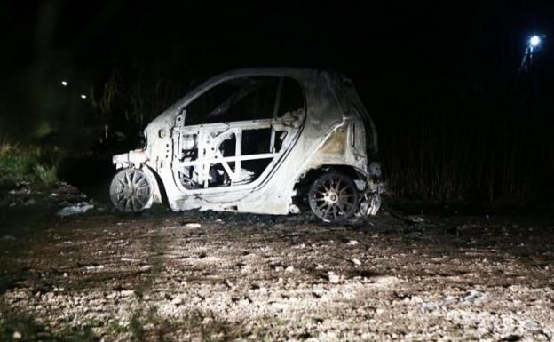 El coche de los atacantes, incendiado.