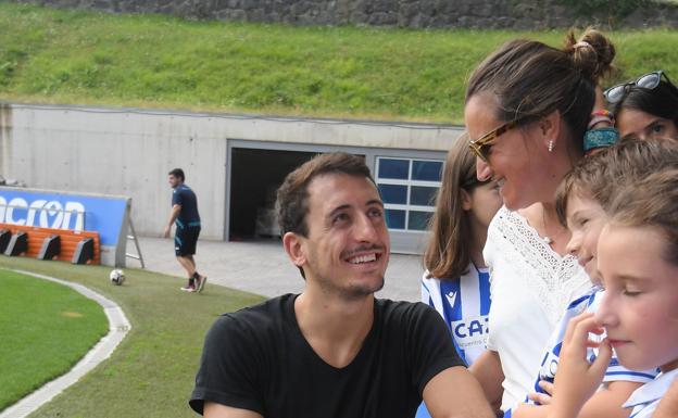 Mikel Oyarzabal sonríe con un grupo de aficionados durante el entrenamiento de ayer en Zubieta. 