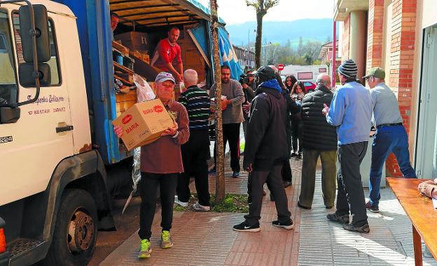 Descarga. Los voluntarios de Nagusilan proceden a llevar los alimentos al nuevo local donde se repartirán entre hoy y mañana. / AMAXKAR