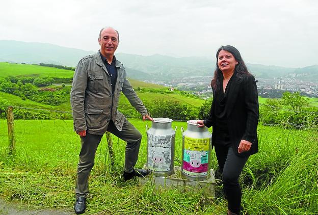 En Talaimendi. Jesus Arana y Gloria Vázquez muestran dos de las marmitas de leche. / ETXEBERRIA