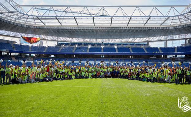 Los trabajadores posan antes del reestreno de Anoeta junto a los jugadores de la Real Sociedad