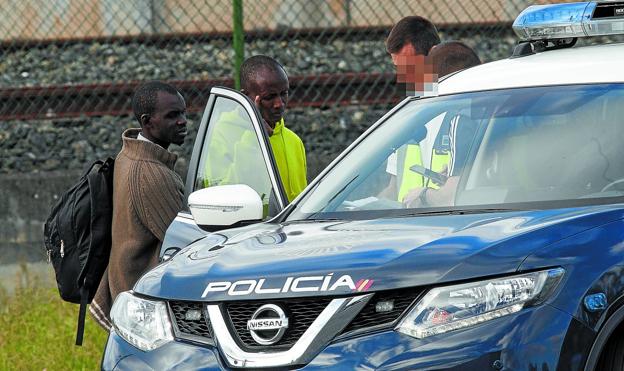 Dos migrantes subsaharianos son registrados por la Policía Nacional en Irun tras ser devueltos por la Gendarmería al ser interceptados en suelo francés. / DE LA HERA