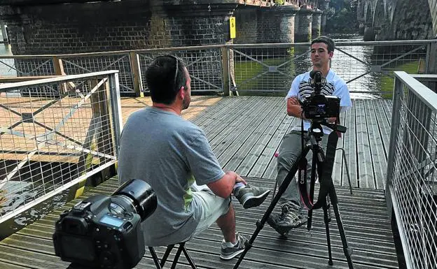Mikel Huarte entrevista a uno de los jóvenes, entre el puente peatonal y el de Euskotren./DV