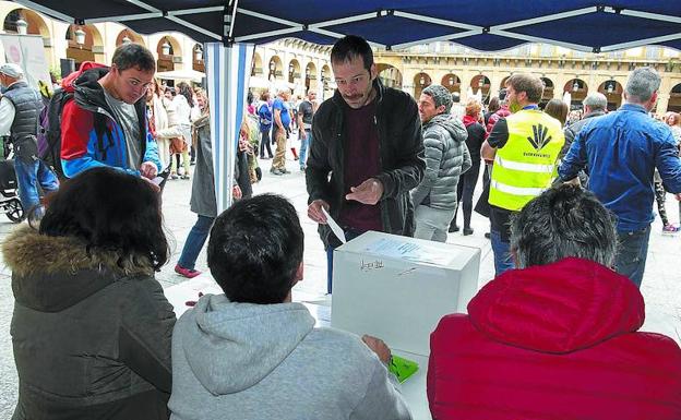 Un joven se dispone a votar en una de las urnas instaladas por Gure Esku Dago en la plaza de la Constitución de San Sebastián. /MICHELENA