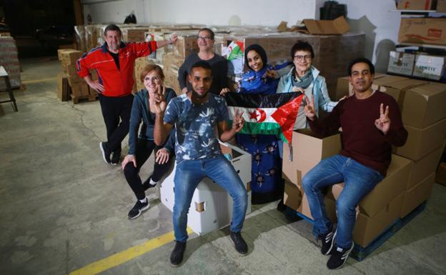 Carga preparada. Un grupo de voluntarios de Tadamum Elkartea posa con la bandera saharaui tras empaquetar los productos./F. DE LA HERA