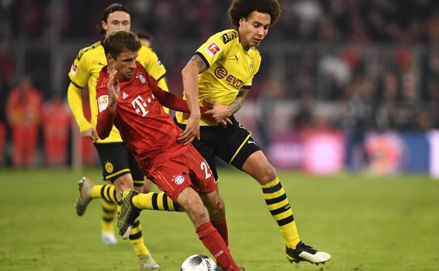 Müller and Witsel dispute a ball during a duel between Bayern Munich and Borussia Dortmund.