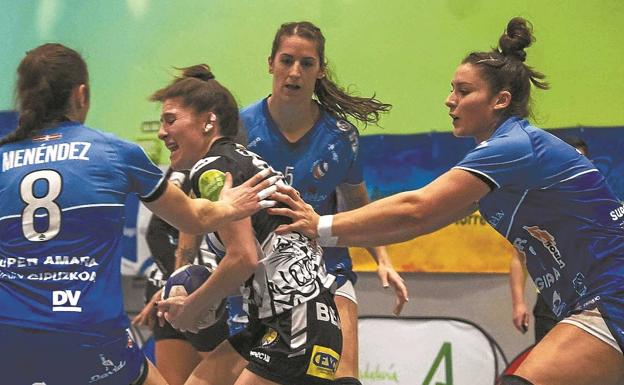 Menéndez y Cesáreo, en el bloque defensivo central, impiden la circulación de una jugadora rival durante el partido en Málaga. /