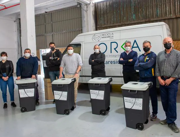 Josema, tercero por la izquierda, rodeado de parte de su equipo en Orka y con los contenedores para mascarillas. / F. DE LA HERA
