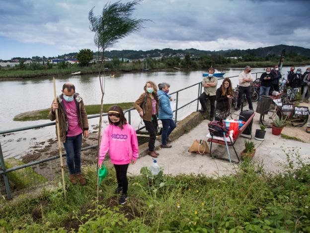Una niña riega el tamarindo recién plantado junto al río. / F. DE LA HERA