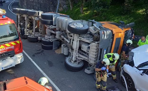 Los bomberos rescatan al conductor de un camión volcado en Usurbil