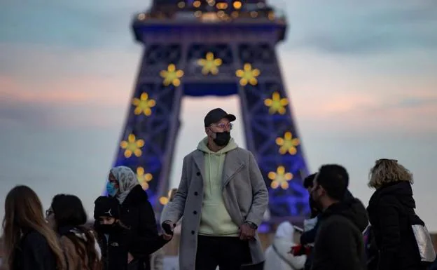 A man with a mask, in front of the Eifel Tower. 