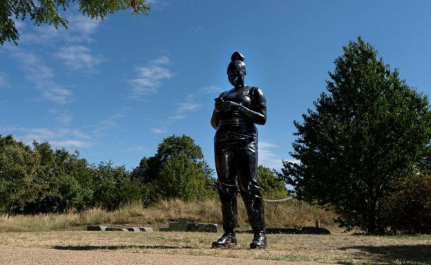 Una mujer negra con un móvil en la campa de Chillida-Leku