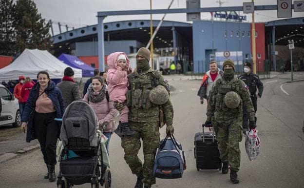 Soldiers help civilians fleeing war cross the border. 