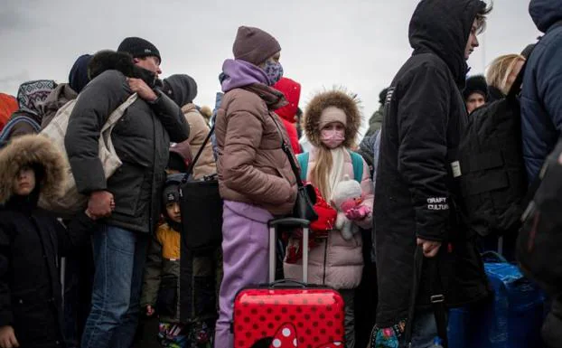Several people and children wait to cross into Romania, at the Porubne border crossing.