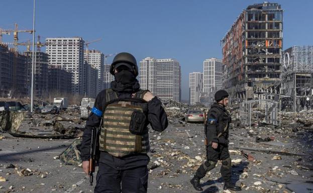Ukrainian forces secure the area after an airstrike on a kyiv shopping center by Kremlin troops.