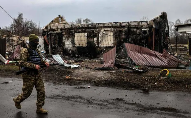 A Ukrainian soldier patrols a street in the town of Lukianivka, on the outskirts of kyiv.
