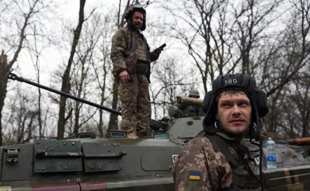 Two Ukrainian soldiers, next to an armored vehicle, in the Kharkov region.