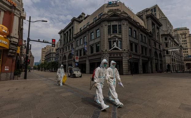 Deserted street in Shanghai, a confined city where security forces work in insulated suits.