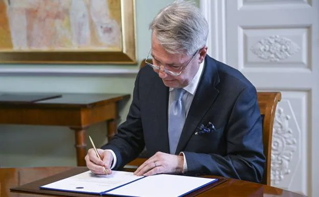 Finnish Foreign Minister Pekka Haavisto signs his country's application for NATO membership in Helsinki.