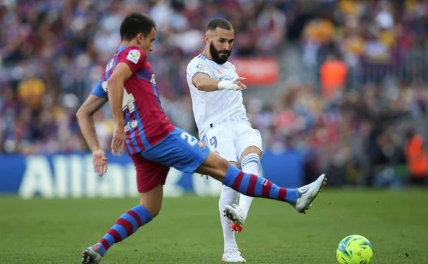 Benzema hits the ball against the opposition of Eric García. 