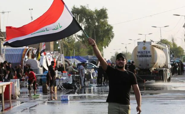 A supporter of cleric Muqtada al-Sadr waves the Iraqi flag in a protest. 
