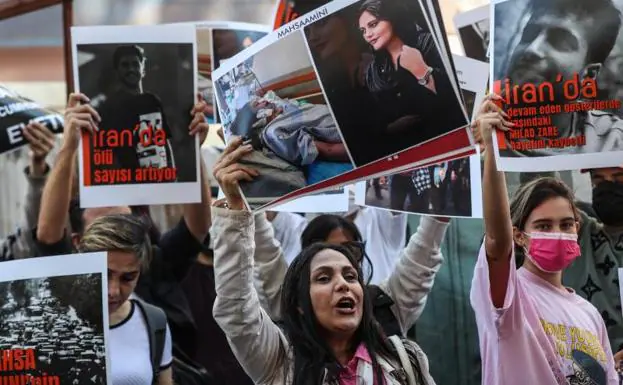 A group of Iranians hold pictures of Mahsa Amini during a protest outside the Iranian consulate following Mahsa Amini's death in Istanbul, Turkey. 