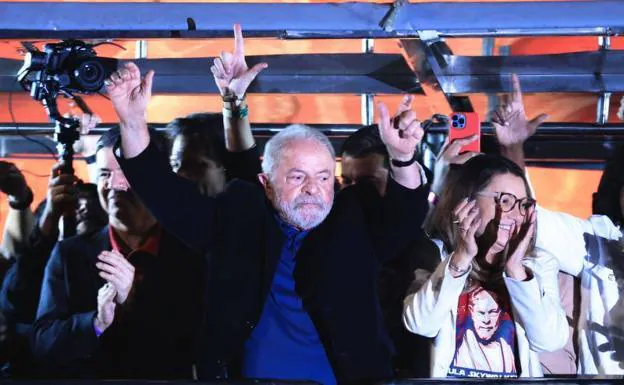 Lula celebrates his results before supporters on Avenida Paulista in Sao Paulo accompanied by his wife, Rosangela da Silva.  Behind him, members of his team gesticulate by making an 'L' with their hands, a symbol of Lula.