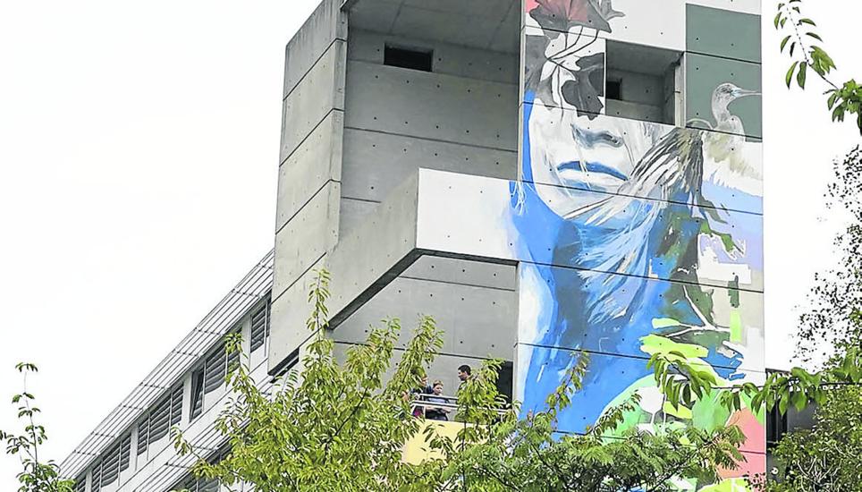 Una mujer con pelo de cormorán mira junto al río