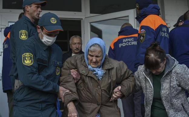 Russian rescuers help evacuate residents from a nursing home on the left bank of the Dnieper River in Kherson.