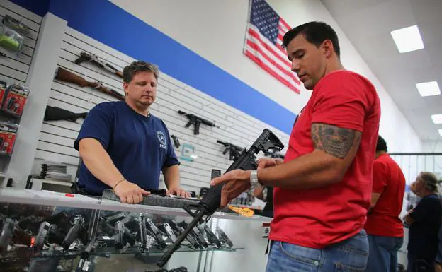 A citizen looks closely at a gun in a Florida gun shop. 