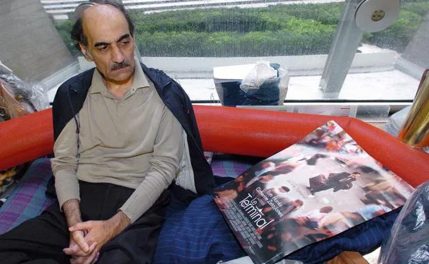 Image from 2004 in which Nasseri looks at a movie poster inspired by his life, in Terminal 1 of Paris Charles De Gaulle airport. 