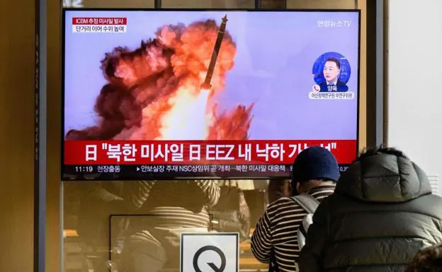 North Korean citizens follow the news about the launch on television. 