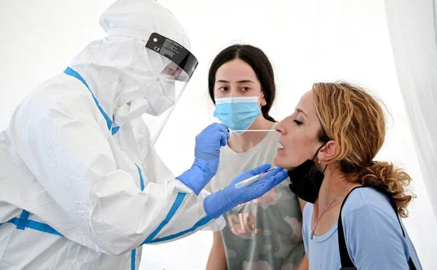 A woman undergoes a PCR test at Cologne Bonn Airport in Cologne, Germany. 