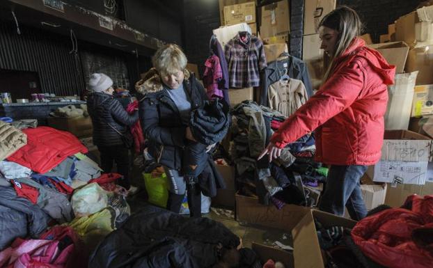 Two volunteers sort clothes at a charity shop in the western Ukrainian city of Lviv. 