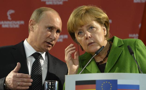 File image in which Vladimir Putin translates a journalist's question to Angela Merkel in Hannover, Germany. 